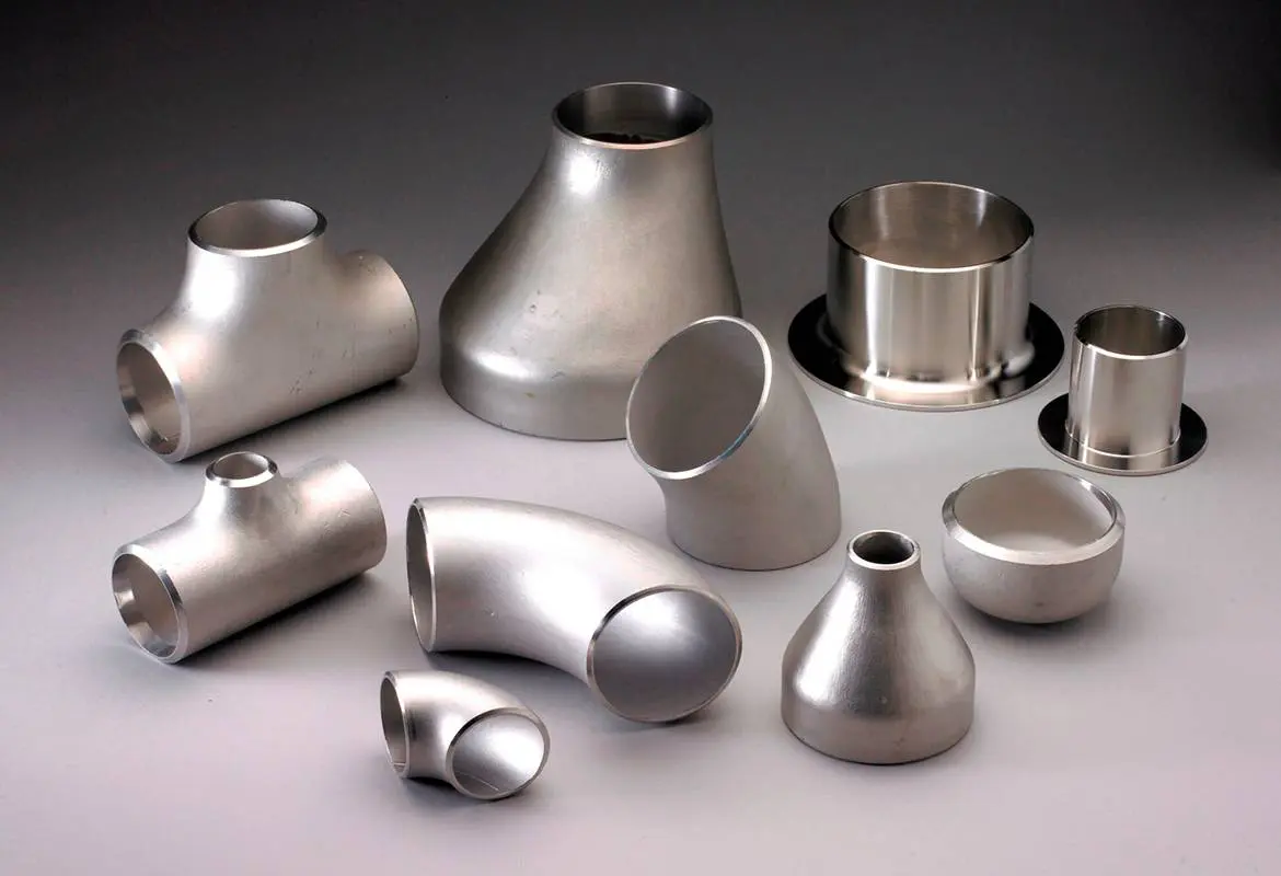 Various stainless steel pipe fittings arranged on a surface.