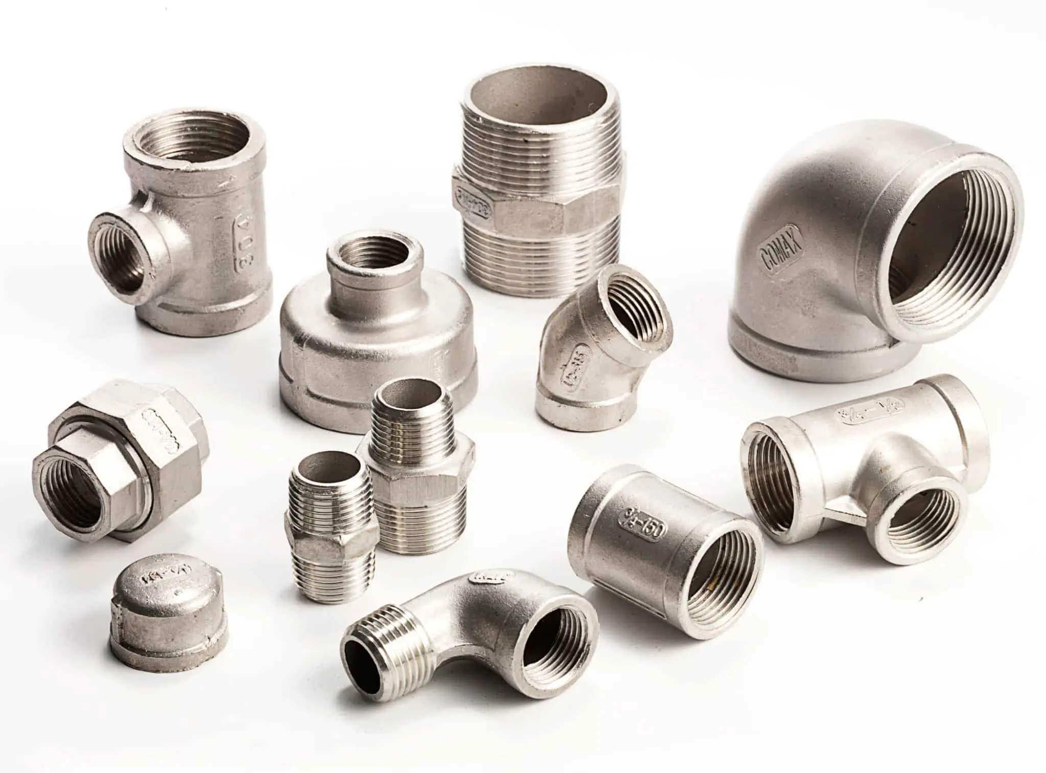 Various metal plumbing fittings arranged on a white surface.