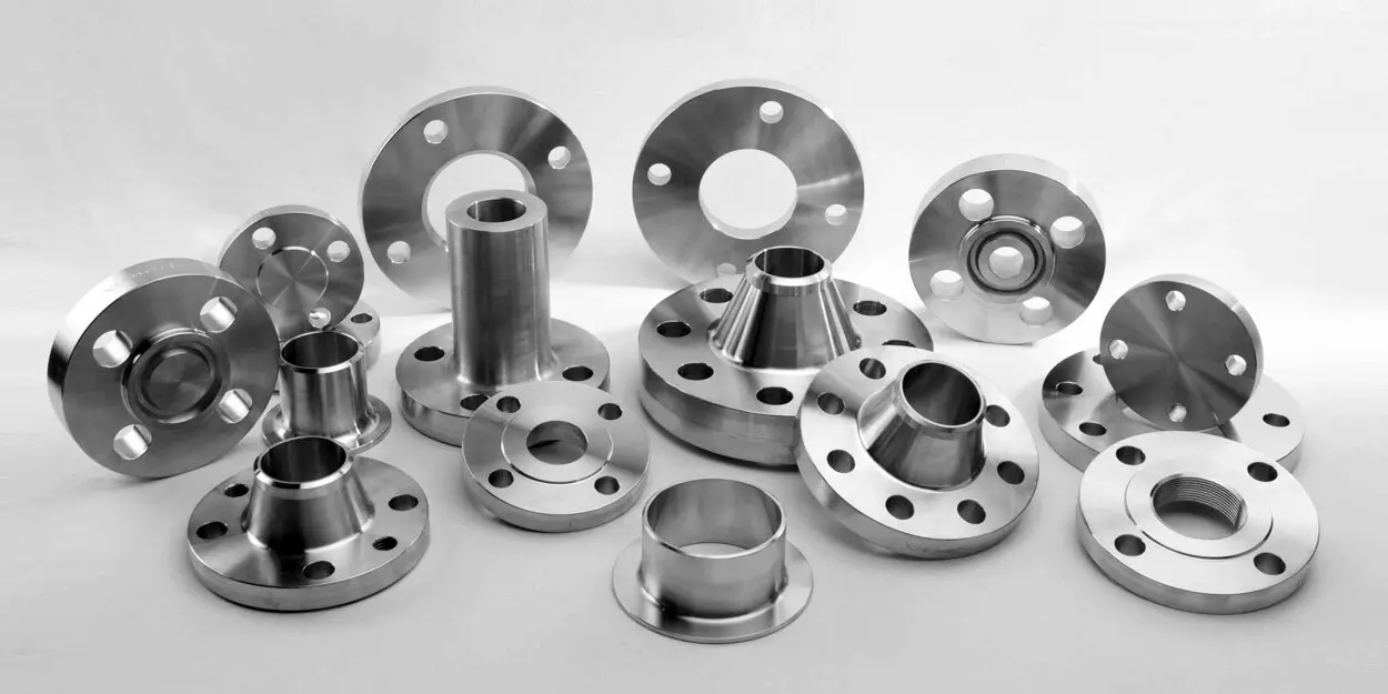 Collection of various metal flanges and fittings arranged on a surface.